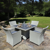 Outdoor patio set with a table and four chairs on a stone patio.