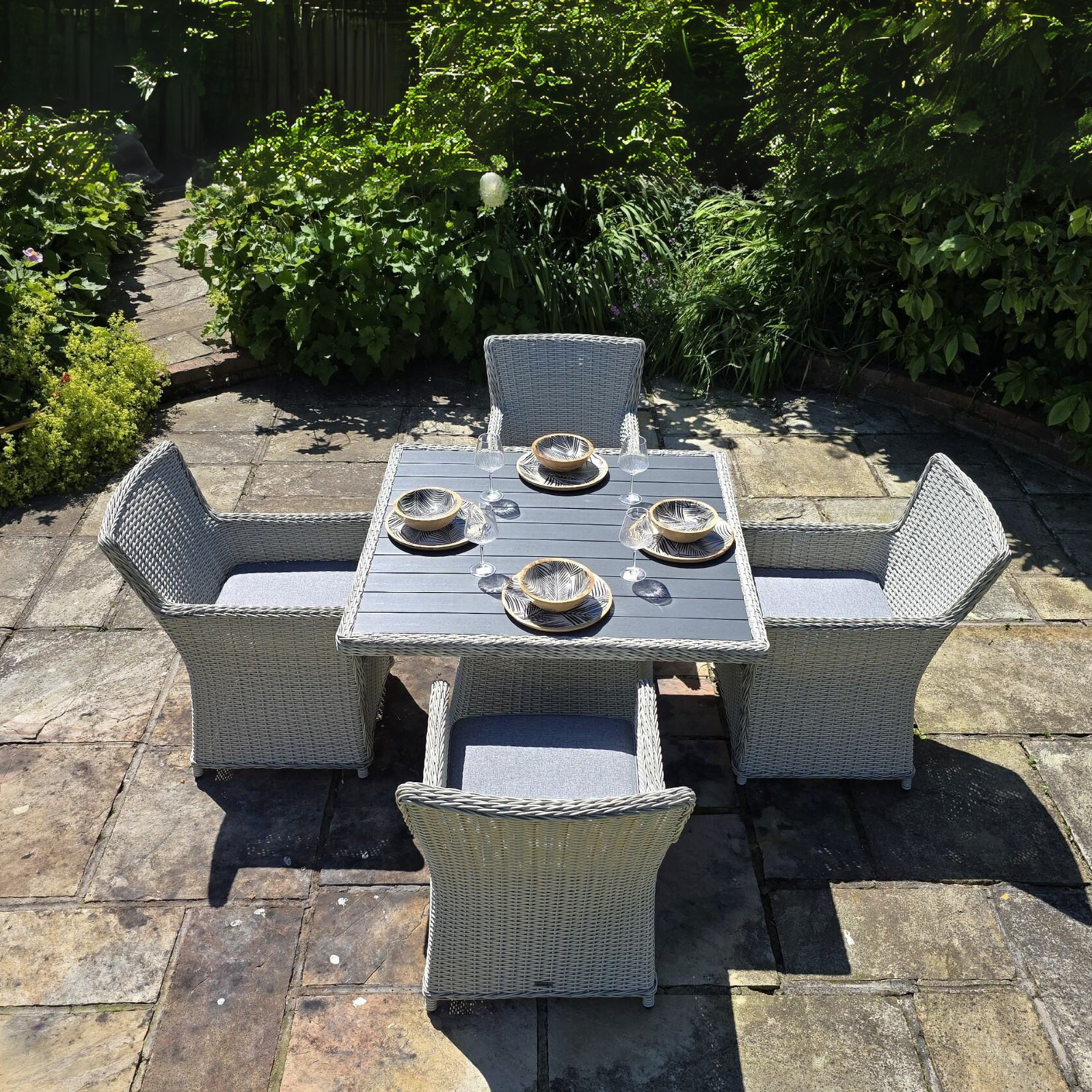 Outdoor patio set with table and chairs on a stone patio