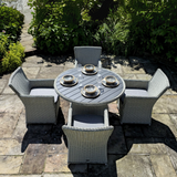 Outdoor patio set with round table and four chairs.