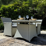 Outdoor patio set with wicker chairs and table in a garden setting